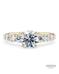 The Lyra diamond band engagement ring with a graduated Princess cut diamond in 18k yellow gold. This ring features a 2.00mm band with a total weight of approx. 0.70ct.